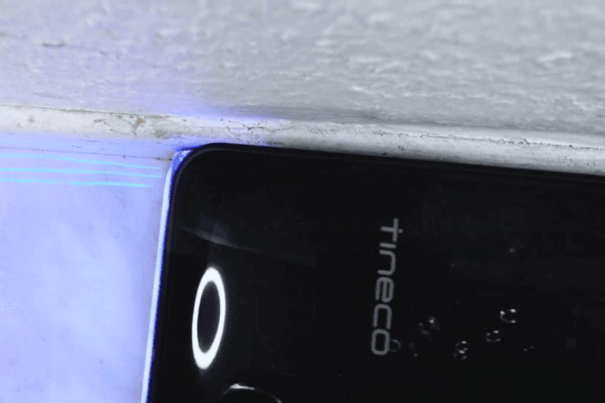 Tineco Floor One S9 Artist Boost Steam Premium reinigt eine Küchenkante neben einem Kind und einem Hund